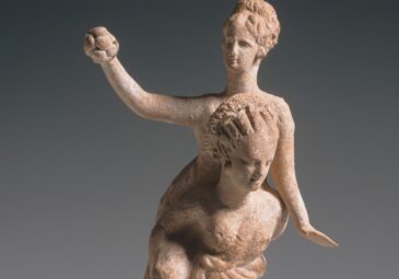 Griechische Tonstatuette zweier Mädchen beim Huckepackspiel. Das Mädchen am Rücken hält einen Ball in der rechten Hand.