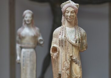 Farbiger Abguss einer griechischen Frauenstatue mit reichem Gewand und Diadem im Haar.
