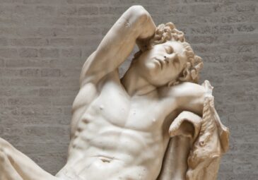 Marmorstatue eines angetrunkenen Satyr, der auf einem Felsen lagert und schläft.