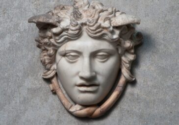 Antiker Reliefkopf der Medusa aus Marmor mit Flügeln und Schlangen um den Hals.