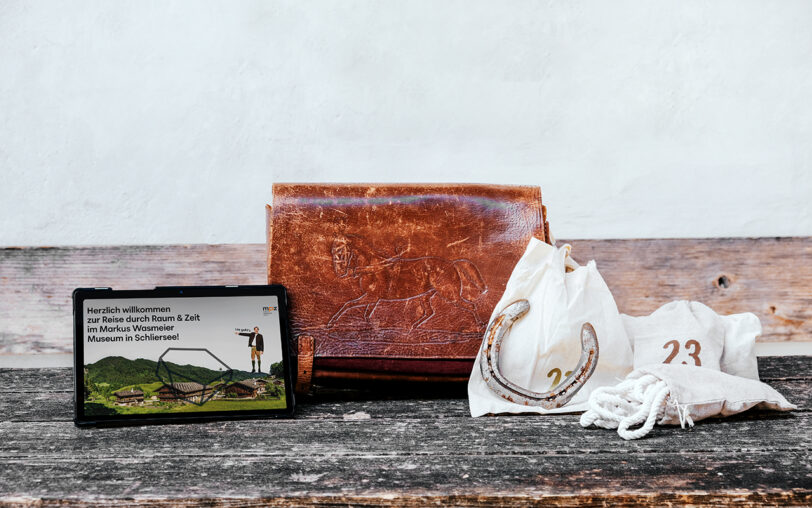 Tablet, Ledertasche und nummerierte Säckchen.