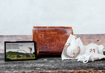 Tablet, Ledertasche und nummerierte Säckchen.