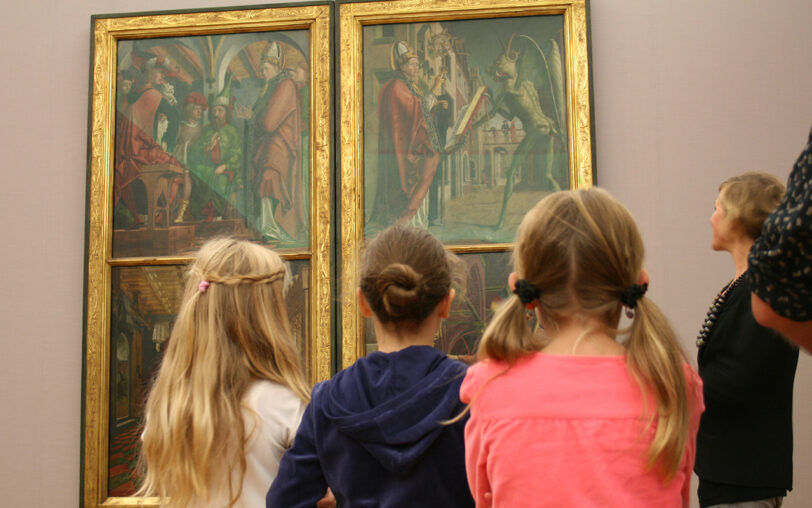 Kinder vor mittelalterlichen Altarbildern.