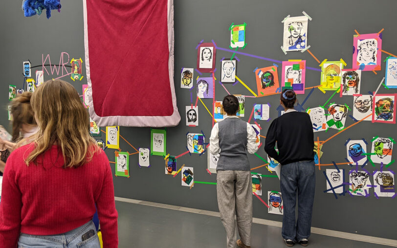 Teilnehmende betrachten gemeinsam die farbenfrohen Ergebnisse ihres Workshops.