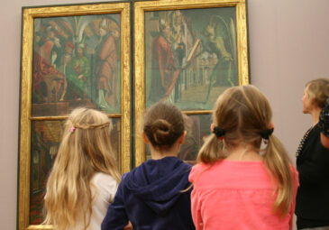 Kinder vor mittelalterlichen Altarbildern.