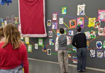 Teilnehmende betrachten gemeinsam die farbenfrohen Ergebnisse ihres Workshops.