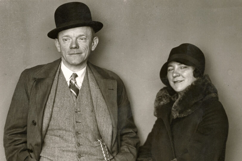 Schwarzweiß-Aufnahme von Karl Valentin und Liesl Karlstadt vor neutralem Hintergrund stehend