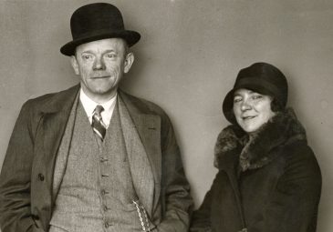 Schwarzweiß-Aufnahme von Karl Valentin und Liesl Karlstadt vor neutralem Hintergrund stehend